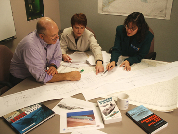 Team examining blueprints of Alligator
